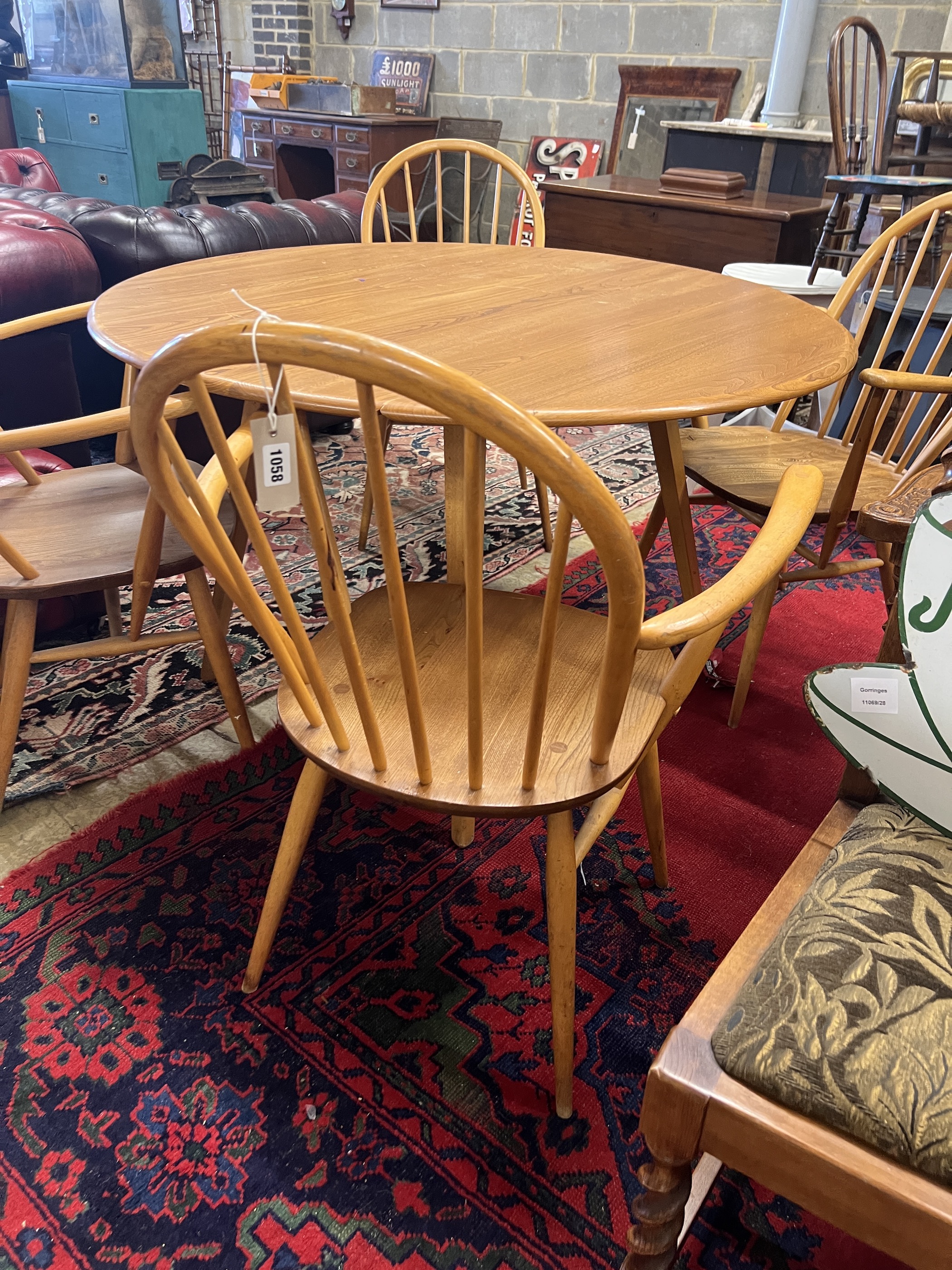 An Ercol oval elm drop leaf dining table, length 123cm extended, width 113cm, height 71cm and four Ercol elm and beech elbow chairs